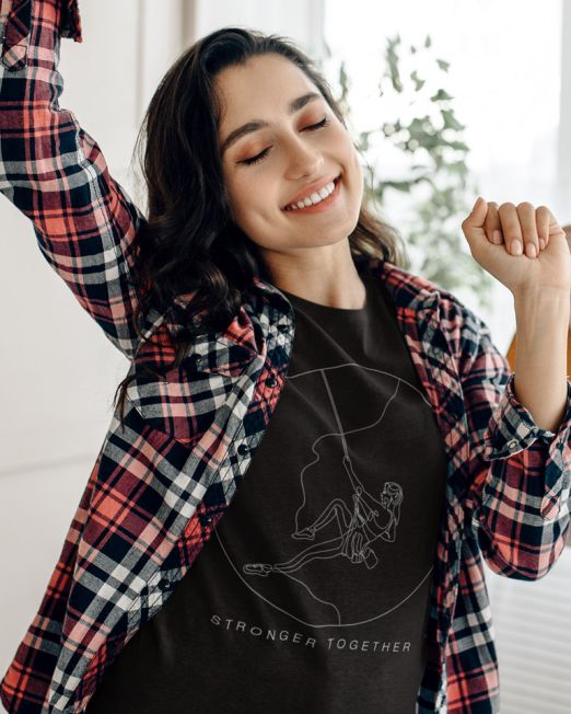 Stronger Together Womans Rock Climbing Black Relax Minimal Outdoor Tshirt Apparel Design of a Girl with dark hair dancing while wearing a red and black flannel shirt while a man plays guitar