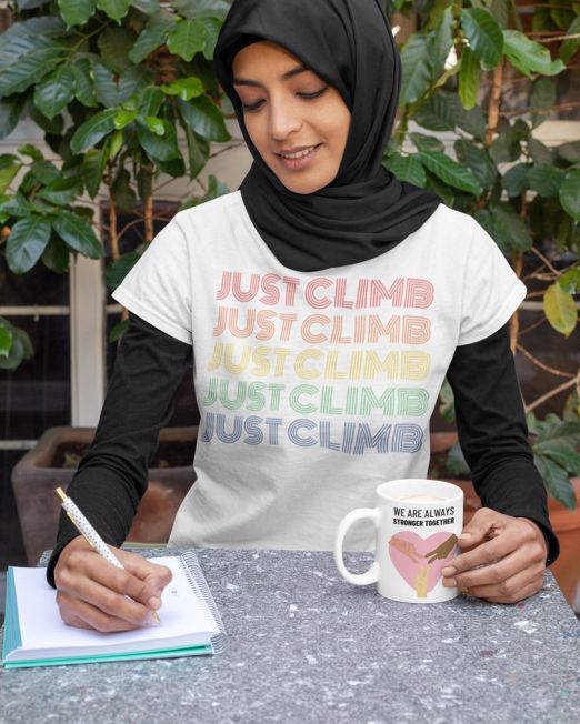 Just-Climb-Rock-Climbing-t-shirt-of-a-young-woman-drinking-from-a-Equality-Designed-coffee-mug-while-working-4x5